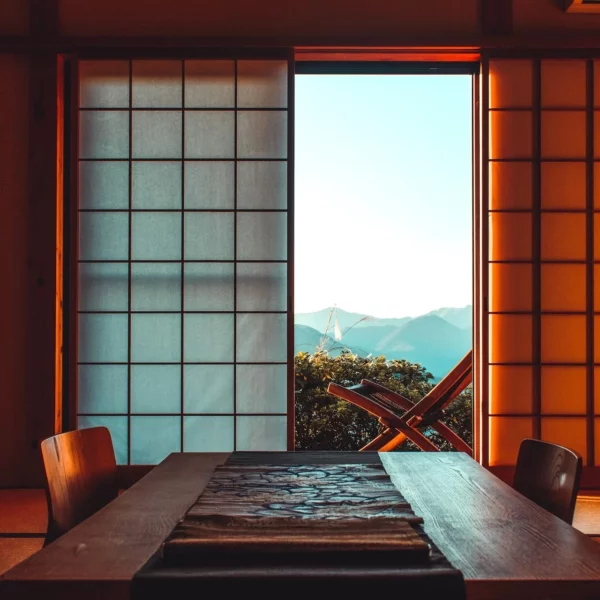 Traditionele Japanse ryokan met open shoji-deuren en uitzicht op bergen tijdens een rondreis Japan.