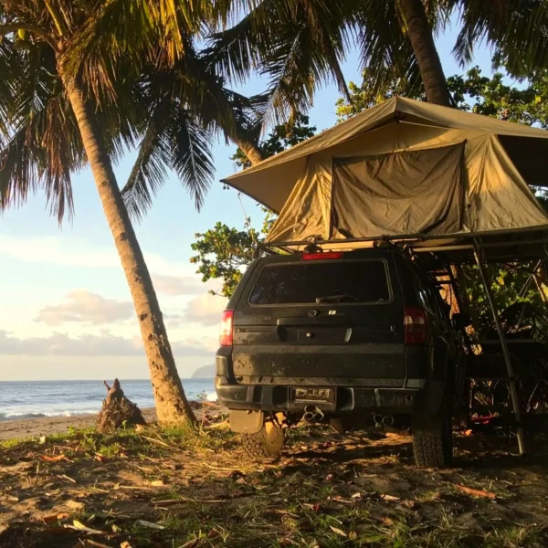 4x4 met daktent wildkamperen bij het strand in Costa Rica.